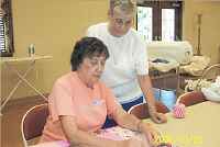 Charla Trenkle at the sewing machine and Phyllis Gilbride working on charity quilts for the Marion County School System.