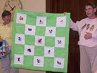 Beth Bender and Jeannette Flint with quilt Jeannette made.